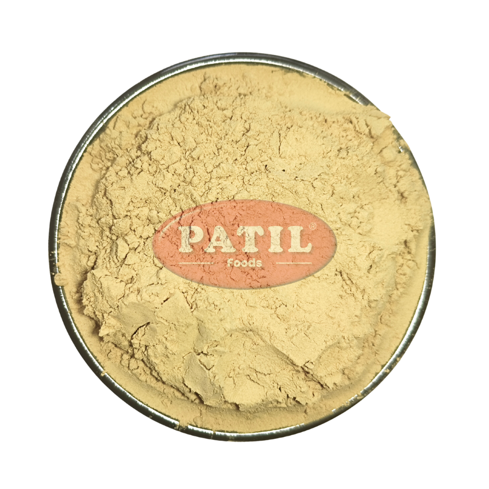 Closeup of Haritaki powder showing fine texture and natural yellowish brown color